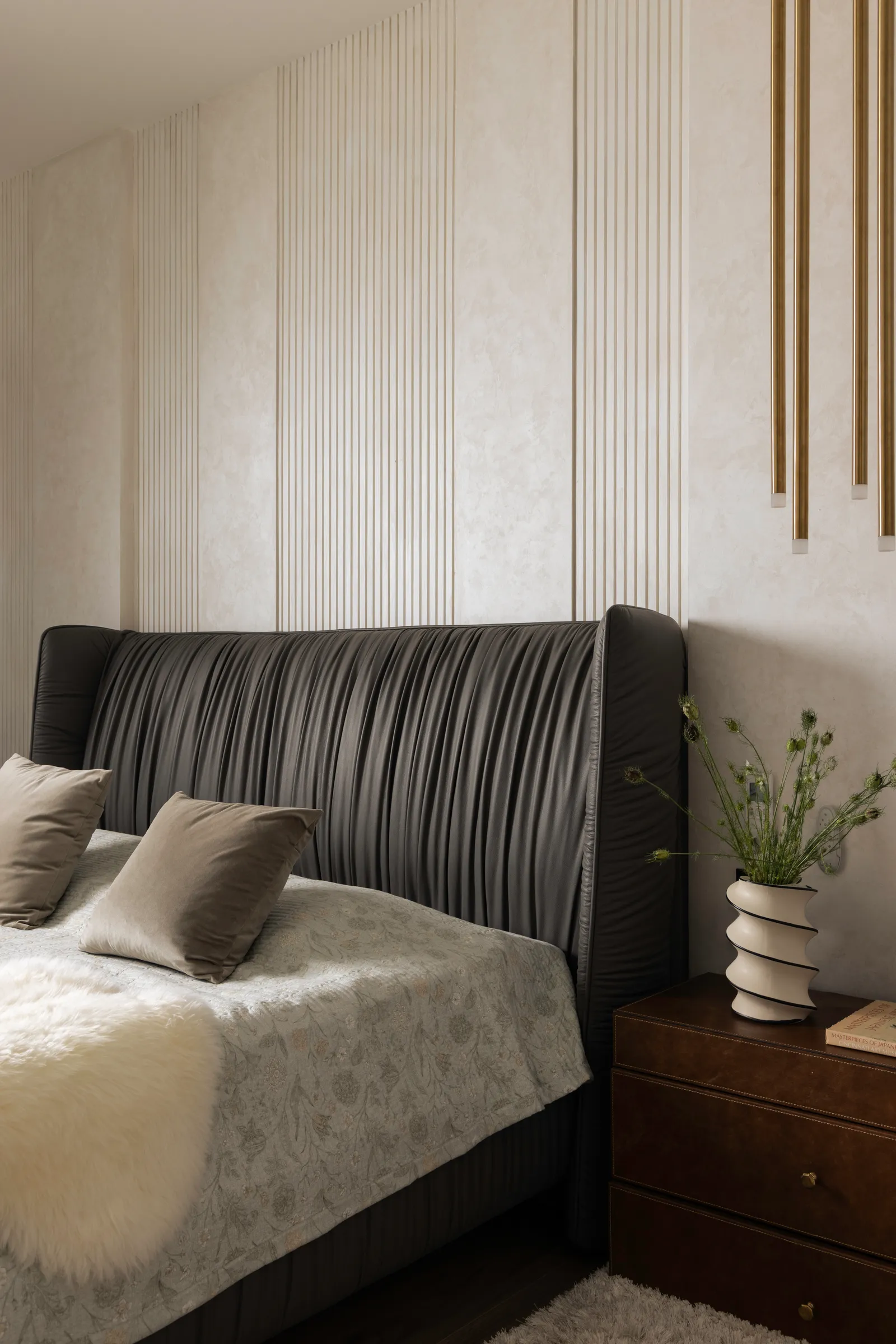 Bed with pleated grey headboard and brass wall accents — Seema Katta Svasa